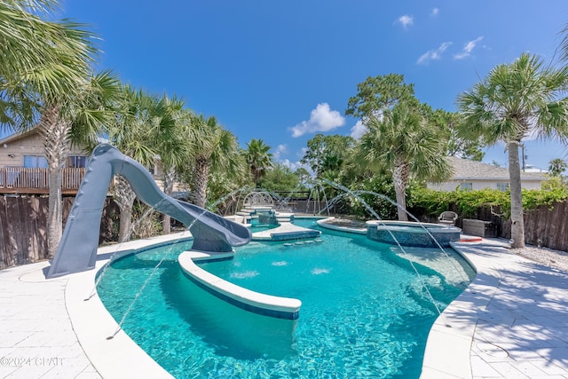 view of pool with an in ground hot tub, a water slide, and pool water feature