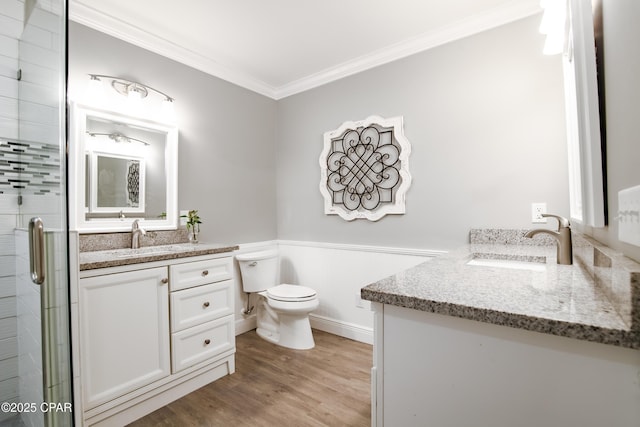 bathroom with walk in shower, crown molding, hardwood / wood-style floors, toilet, and vanity