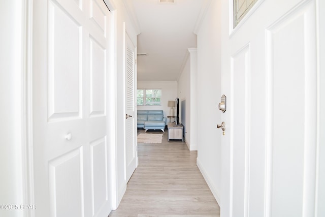 hall with light wood-type flooring and crown molding