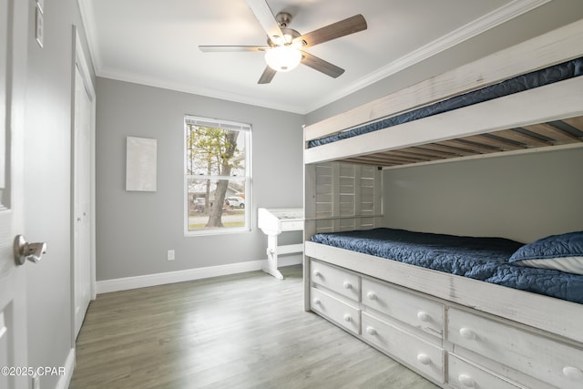 bedroom with hardwood / wood-style flooring, ceiling fan, crown molding, and a closet