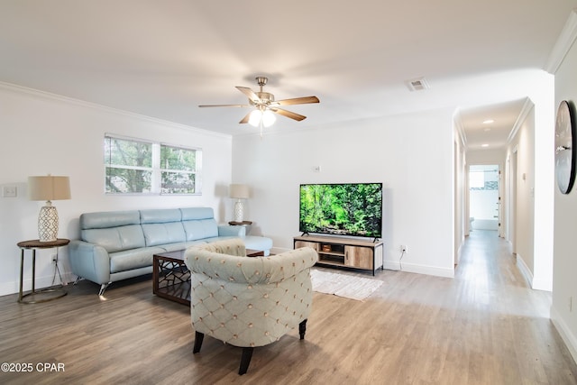 living room featuring light wood-type flooring, ceiling fan, and ornamental molding