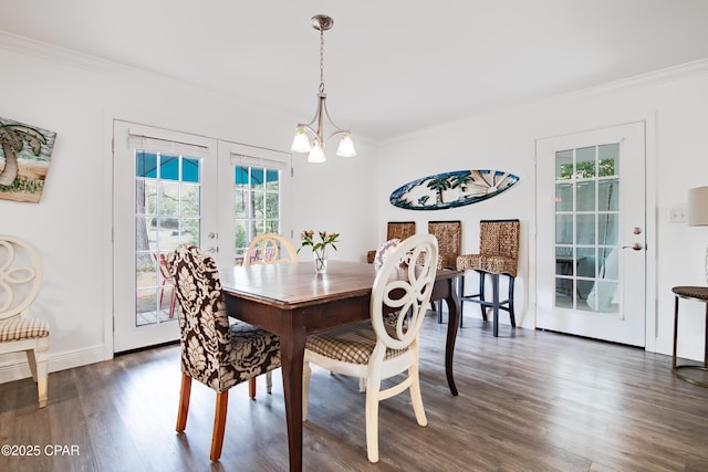 dining room featuring a healthy amount of sunlight, ornamental molding, dark wood-type flooring, and french doors