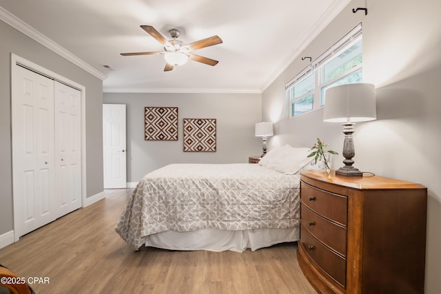 bedroom with light hardwood / wood-style floors, a closet, crown molding, and ceiling fan