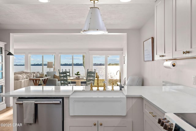 kitchen featuring pendant lighting, dishwasher, a water view, and white cabinets