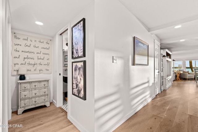 hallway with beam ceiling and light hardwood / wood-style floors