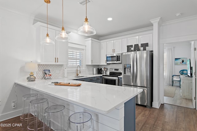 kitchen with sink, hanging light fixtures, stainless steel appliances, white cabinets, and kitchen peninsula