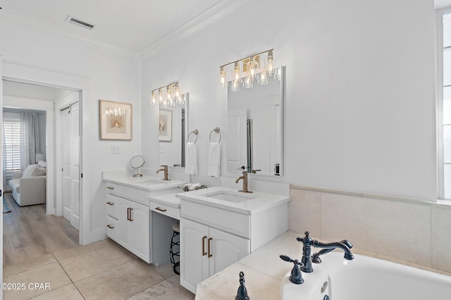 bathroom featuring ornamental molding, a bathing tub, tile patterned flooring, and vanity