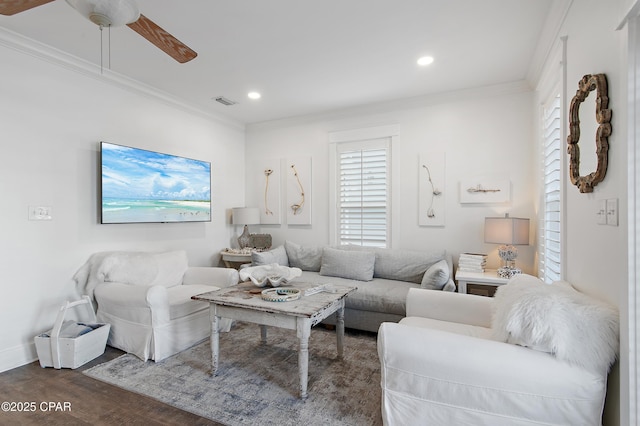 living room with ornamental molding, dark wood-type flooring, and ceiling fan