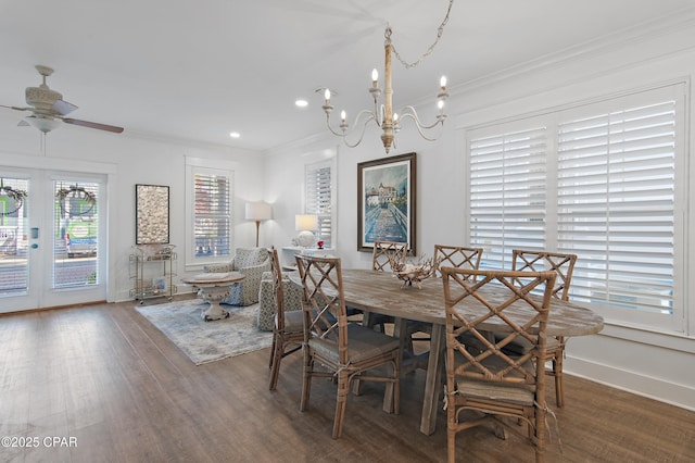 dining space featuring ornamental molding, ceiling fan with notable chandelier, and wood-type flooring