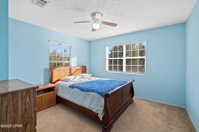 carpeted bedroom featuring a textured ceiling and ceiling fan