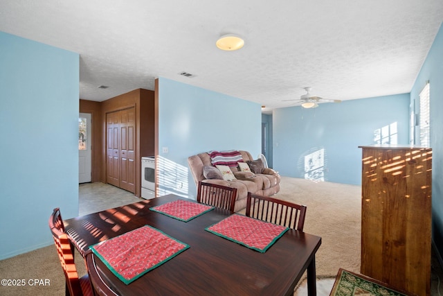 carpeted dining area with ceiling fan and a textured ceiling