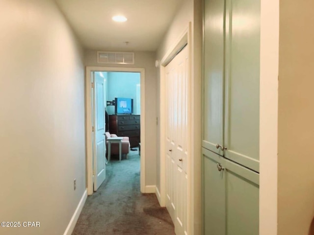 hallway with dark colored carpet