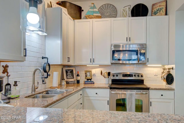 kitchen featuring white cabinets, backsplash, sink, and stainless steel appliances