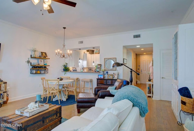 living room featuring ceiling fan with notable chandelier, light hardwood / wood-style flooring, and ornamental molding