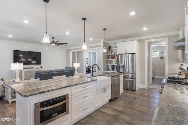 6509 W Sundew Marsh Trl, Panama City Beach, FL 32413 - kitchen with stainless steel appliances, a sink, light stone countertops, white cabinetry, and dark wood-type flooring