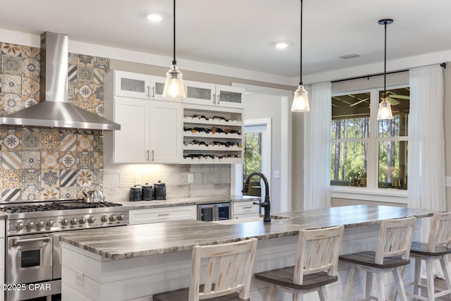 6509 W Sundew Marsh Trl, Panama City Beach, FL 32413 - kitchen featuring range with two ovens, wall chimney exhaust hood, a sink, backsplash, and glass insert cabinets