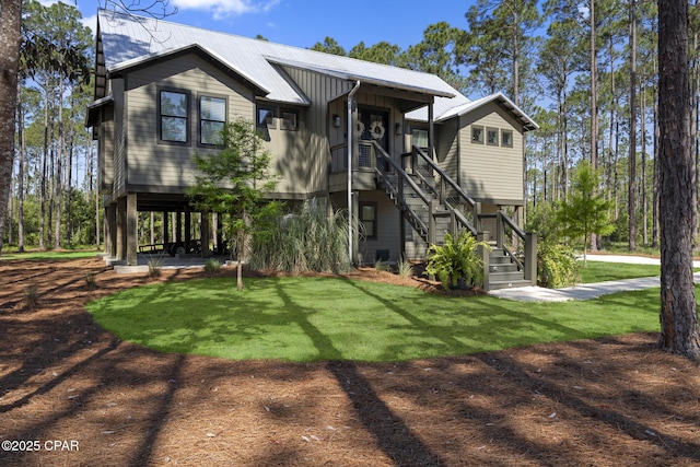 6509 W Sundew Marsh Trl, Panama City Beach, FL 32413 - view of front of home featuring stairway, a front lawn, and metal roof
