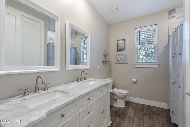 6509 W Sundew Marsh Trl, Panama City Beach, FL 32413 - bathroom with wood finished floors, baseboards, double vanity, and toilet
