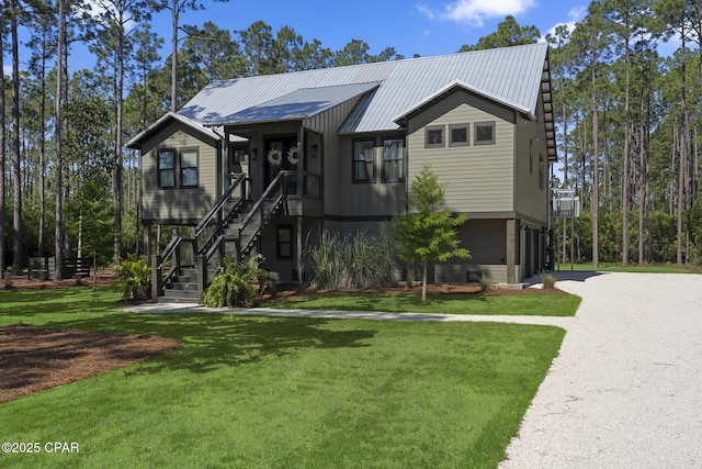 6509 W Sundew Marsh Trl, Panama City Beach, FL 32413 - view of front of house featuring a front lawn, metal roof, and stairway