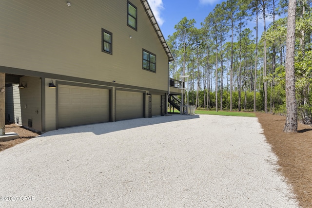 6509 W Sundew Marsh Trl, Panama City Beach, FL 32413 - view of side of home with a garage, stairs, and gravel driveway