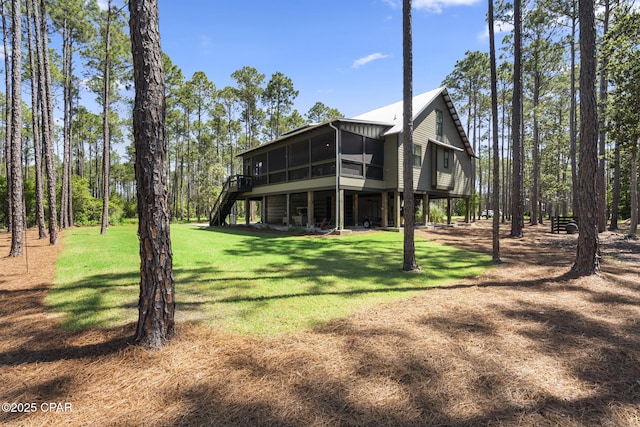 6509 W Sundew Marsh Trl, Panama City Beach, FL 32413 - back of house with stairs, a yard, a sunroom, and a wooden deck
