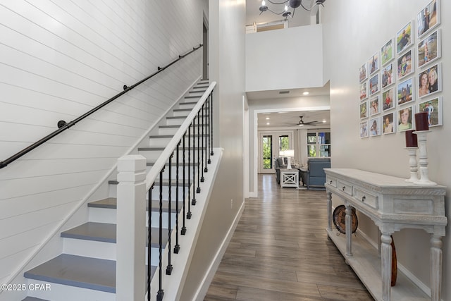 6509 W Sundew Marsh Trl, Panama City Beach, FL 32413 - staircase with wood finished floors, ceiling fan, baseboards, and a towering ceiling