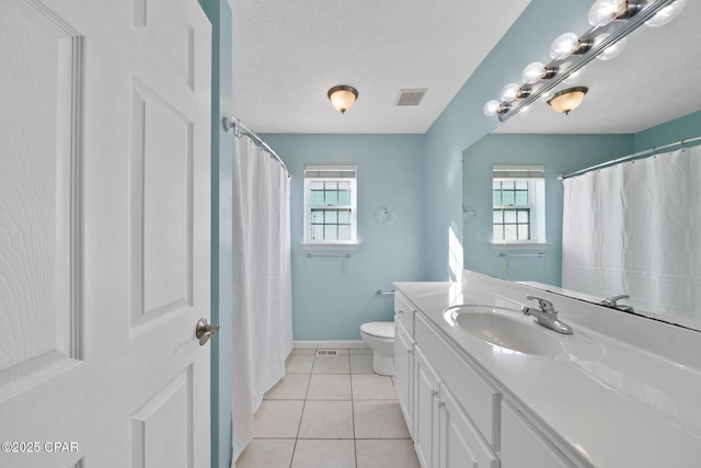 bathroom with tile patterned flooring, vanity, toilet, and a textured ceiling