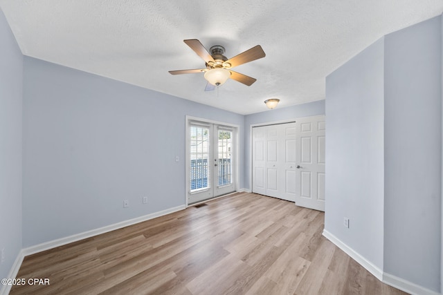 unfurnished bedroom with french doors, ceiling fan, a textured ceiling, light hardwood / wood-style floors, and a closet