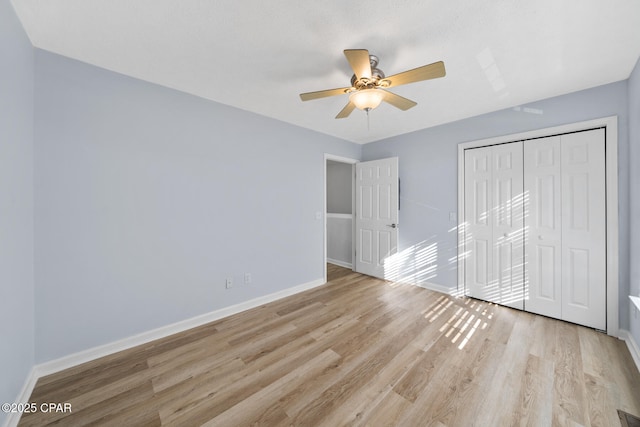 unfurnished bedroom with ceiling fan, light wood-type flooring, and a closet