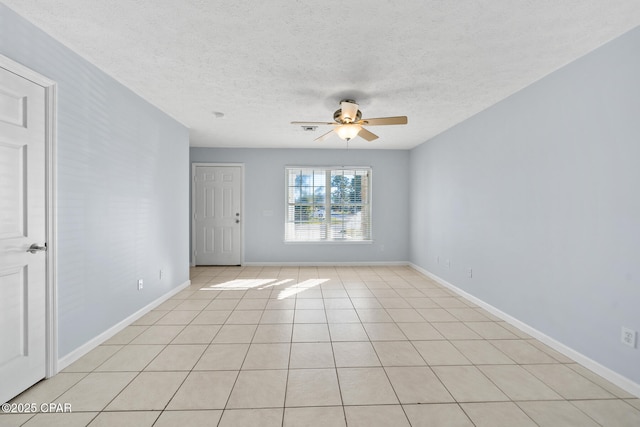 tiled empty room featuring ceiling fan and a textured ceiling