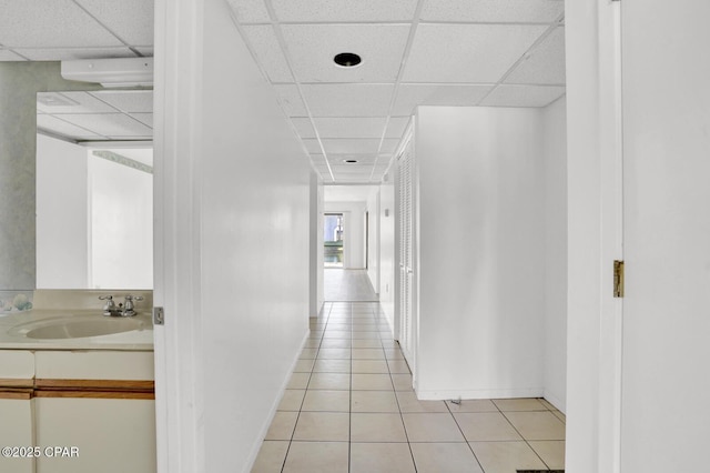 corridor with light tile patterned floors and sink