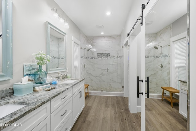 bathroom with hardwood / wood-style floors, vanity, and a shower with shower door