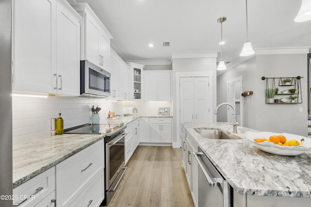 kitchen featuring pendant lighting, sink, white cabinetry, and stainless steel appliances