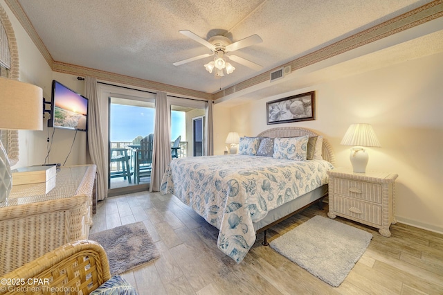 bedroom with a textured ceiling, light hardwood / wood-style floors, ceiling fan, ornamental molding, and access to exterior