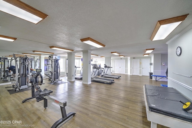 gym featuring a textured ceiling and crown molding