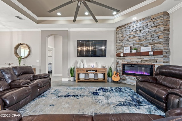 living room featuring crown molding, concrete floors, ceiling fan, and a fireplace