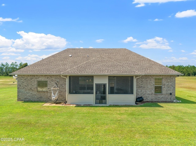 rear view of property with a lawn and a sunroom