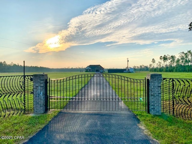 gate at dusk with a lawn and a rural view