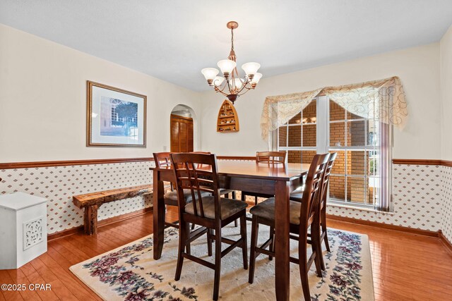 dining space with light hardwood / wood-style flooring and a chandelier