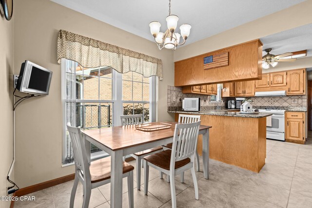 dining space featuring light tile patterned floors, ceiling fan with notable chandelier, and sink