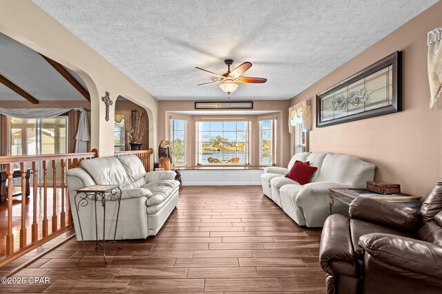 living room featuring ceiling fan and a textured ceiling