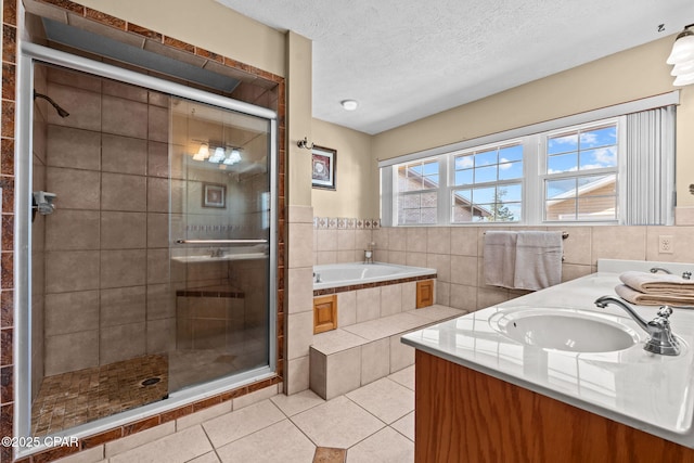 bathroom with vanity, tile patterned floors, independent shower and bath, and a textured ceiling