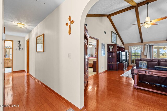 interior space with hardwood / wood-style floors, vaulted ceiling with beams, and a textured ceiling