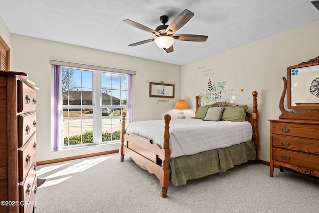 carpeted bedroom featuring a textured ceiling and ceiling fan