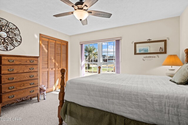 bedroom featuring carpet, access to exterior, ceiling fan, a textured ceiling, and a closet