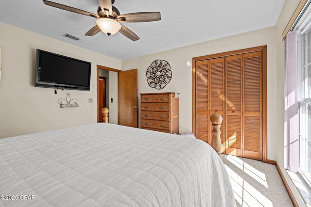 carpeted bedroom with ceiling fan and a closet