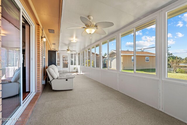 unfurnished sunroom with ceiling fan and a healthy amount of sunlight