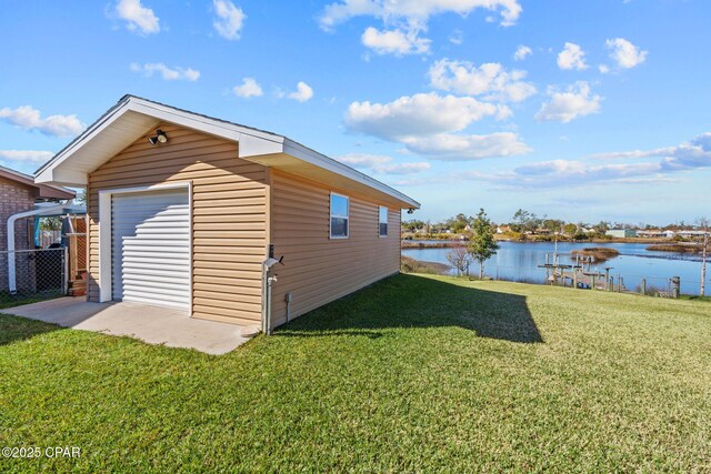 exterior space with a yard, a water view, and a garage