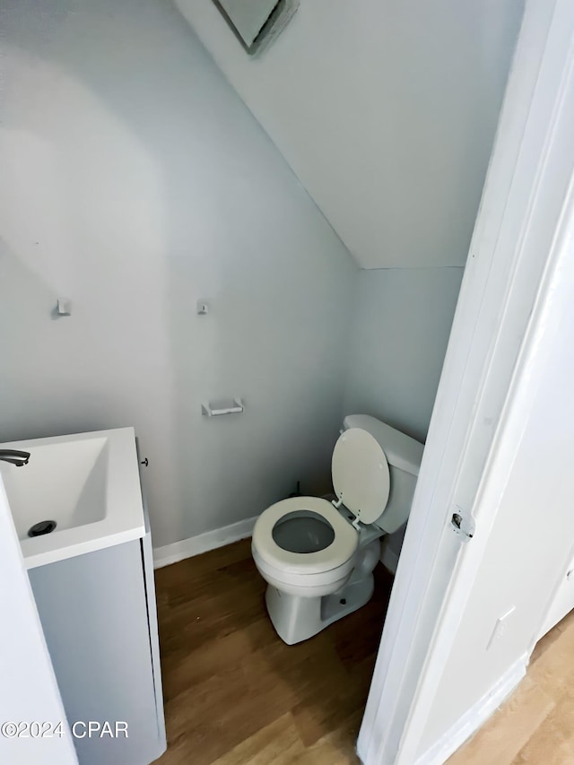 1730 Mallard Dr Apt F, Panama City, FL 32404 - bathroom featuring vaulted ceiling, toilet, baseboards, a sink, and wood finished floors