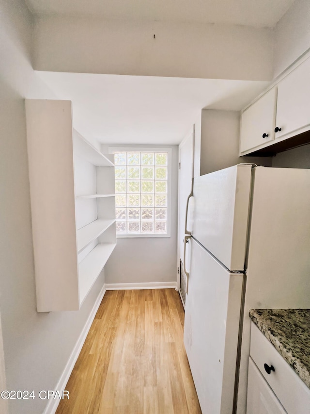 1730 Mallard Dr Apt F, Panama City, FL 32404 - kitchen featuring freestanding refrigerator, white cabinets, baseboards, and light wood-type flooring